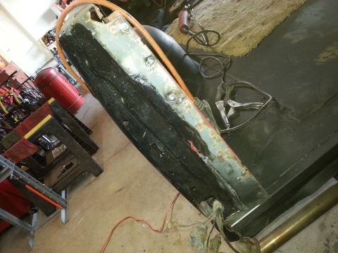 Photo of a vehicle bed or quarter panel laid down during restoration in a garage