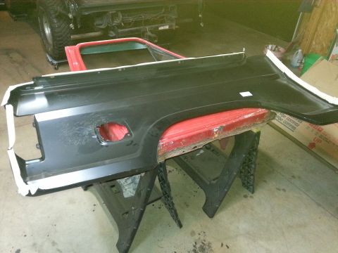 Photo of a vehicle bedside panel on sawhorses during paint prep