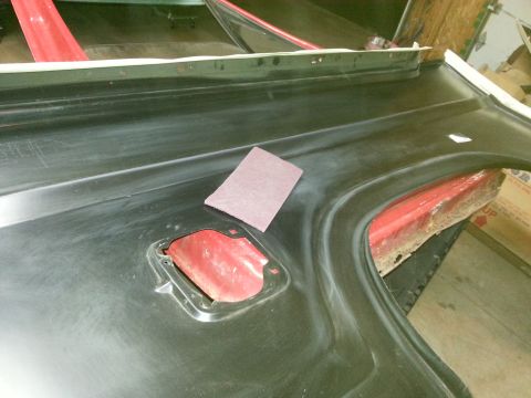 Photo of a black-coated vehicle panel with fuel-filler opening on sawhorses