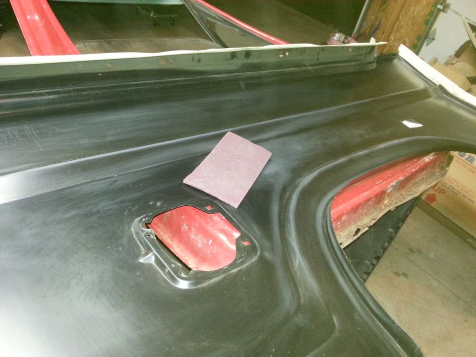 Photo of a black-coated vehicle panel with fuel-filler opening on sawhorses