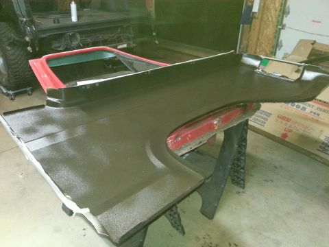 Photo of a bedliner-coated vehicle panel on sawhorses in a garage