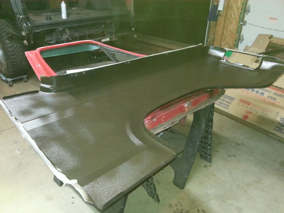 Photo of a bedliner-coated vehicle panel on sawhorses in a garage