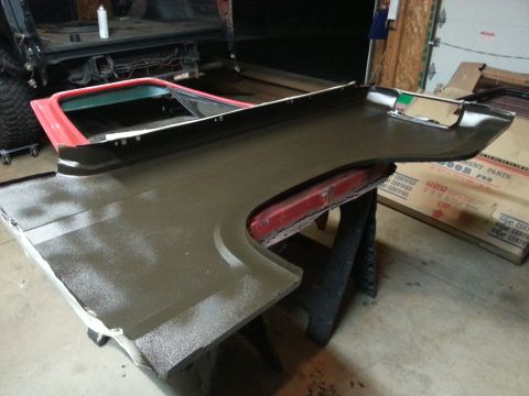 Photo of a textured-coated vehicle bedside panel on sawhorses in a garage