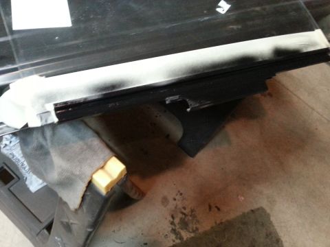 Photo of a vehicle door with glass and weatherstrip during reassembly