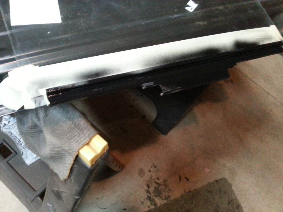 Photo of a vehicle door with glass and weatherstrip during reassembly