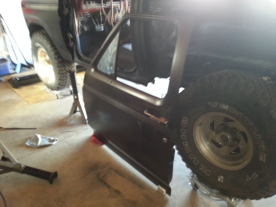 Photo of a painted vehicle door mounted on a truck during reassembly
