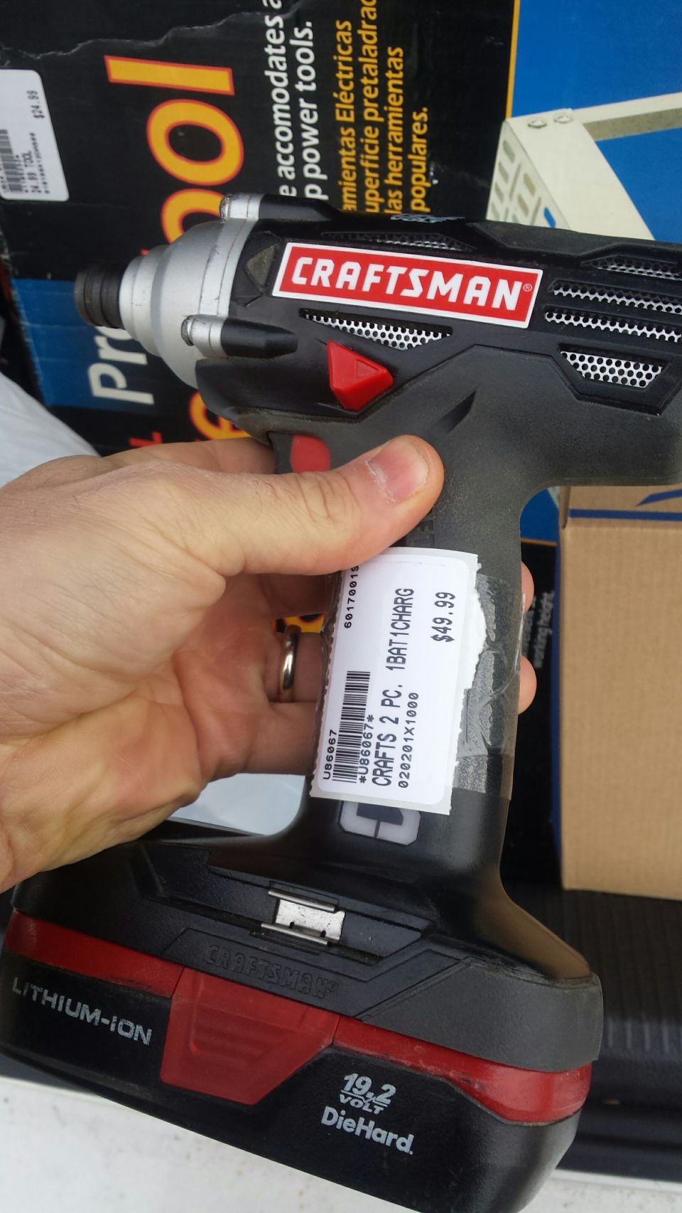 Hand holding a Craftsman lithium-ion cordless impact driver with price tag