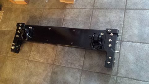 Black fabricated steel bumper or crossmember on a tile floor