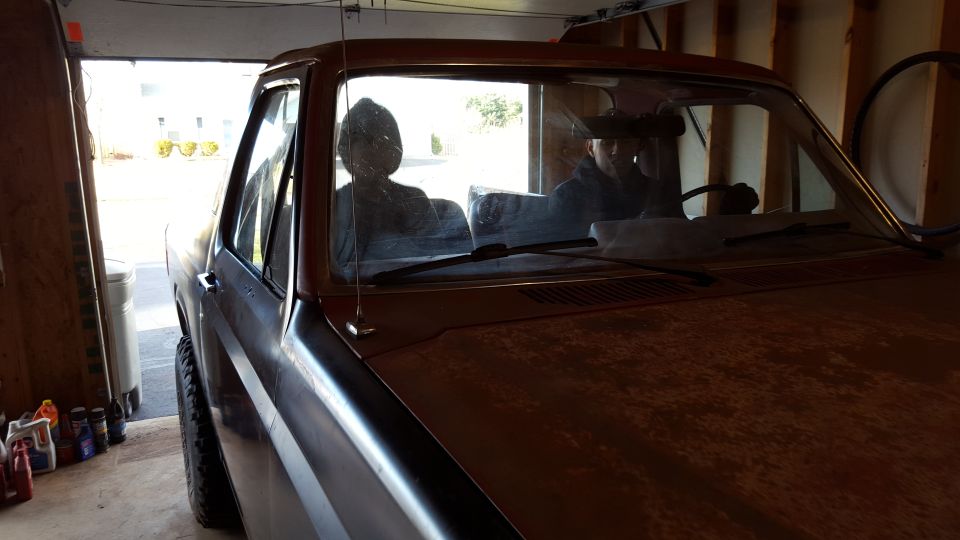 Windshield and cab of a classic vehicle parked in a garage