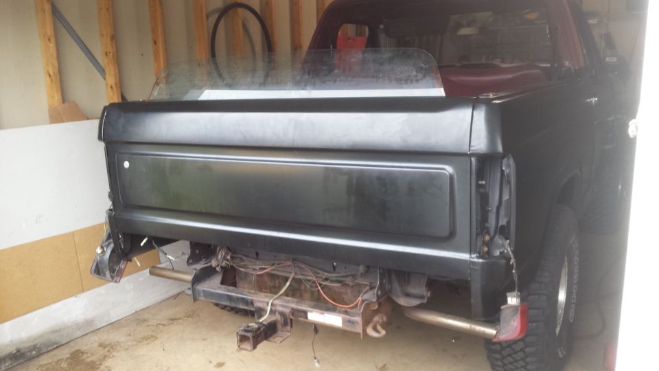 Rear bed and tailgate area of a classic Bronco in a garage