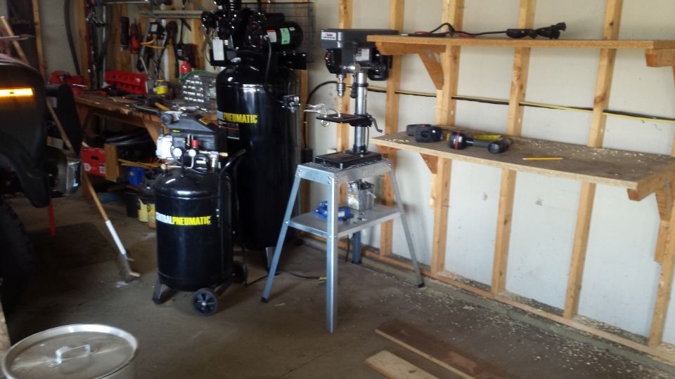 Air compressors and drill press in a garage workshop