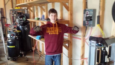 Person in Minnesota hoodie standing in a garage workshop