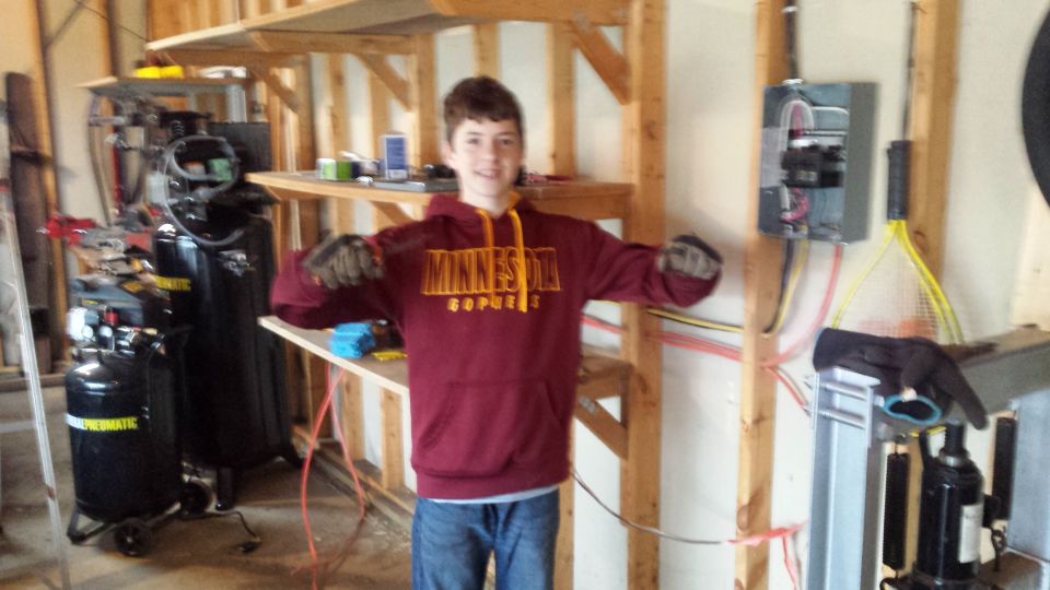 Person in Minnesota hoodie standing in a garage workshop