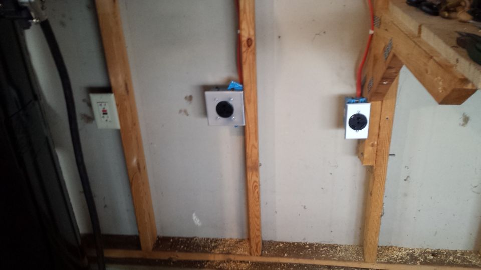 Wall electrical outlets and conduit on a framed garage wall