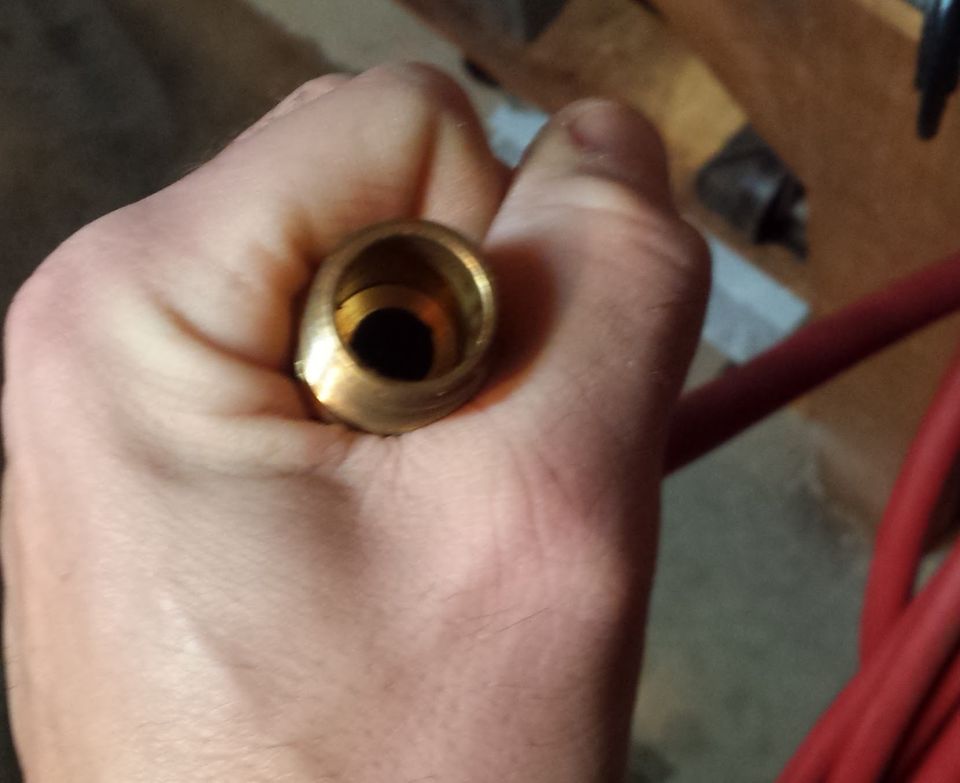 Close-up of a brass fitting held in a hand