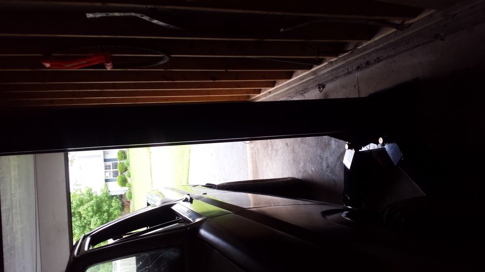 Interior garage view of a vehicle near a low ceiling and open door