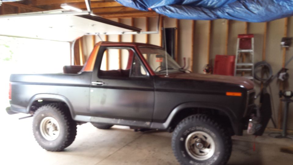 Black Ford Bronco parked inside a wood-framed garage