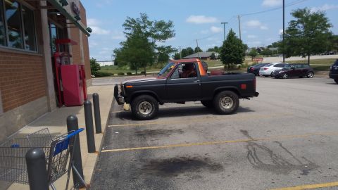 Black Ford Bronco parked outside a convenience store