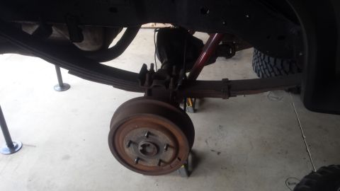 Rear axle, drum brake, and leaf spring of a truck on jack stands