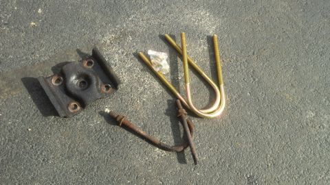 Cast spring bracket, U-bolts, and shock hardware on pavement
