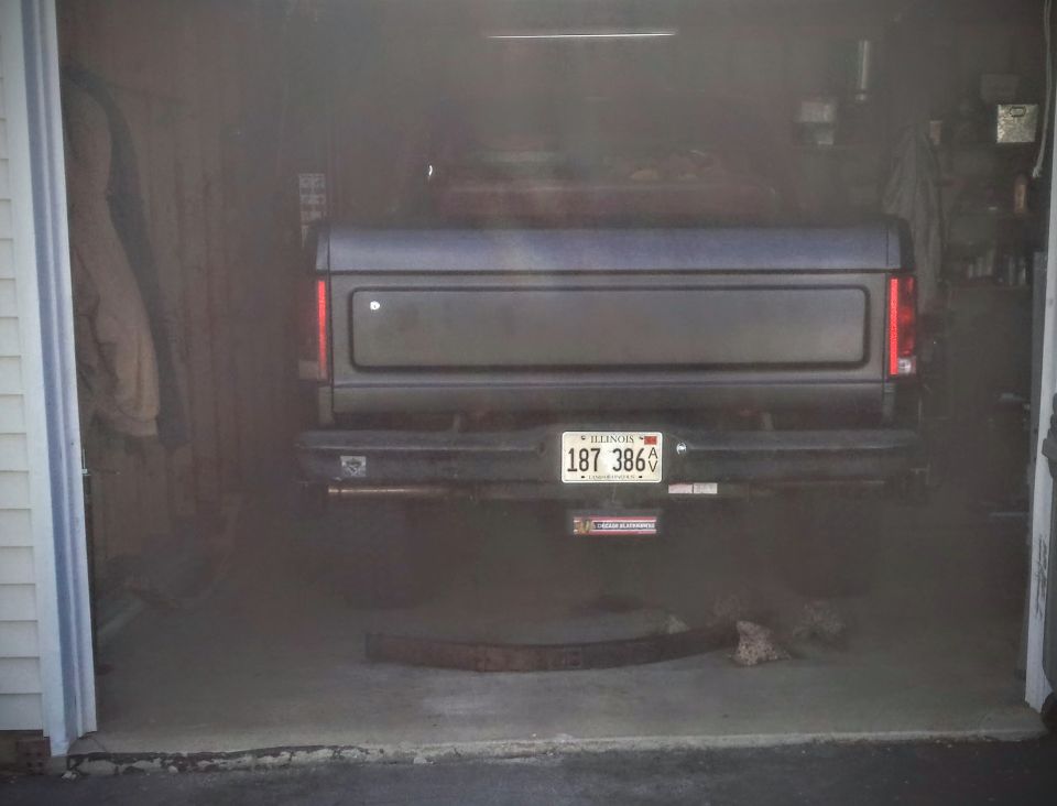 Rear tailgate and bumper of a pickup in a garage with Illinois plate