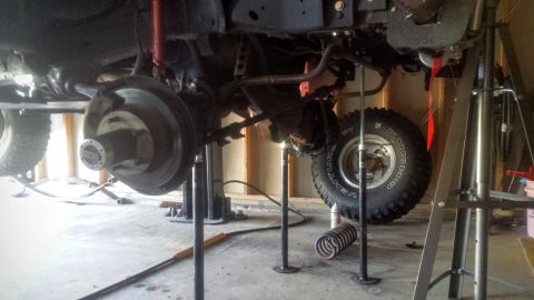 Front axle and suspension of a truck on jack stands with coil spring