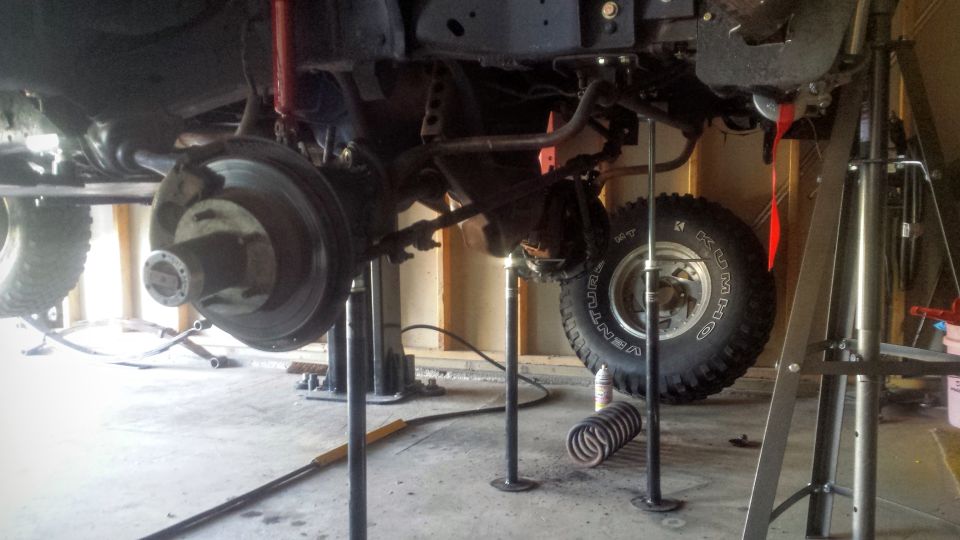 Front axle and suspension of a truck on jack stands with coil spring