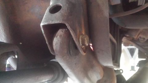 Close-up of a rusty suspension bracket and mounting hardware