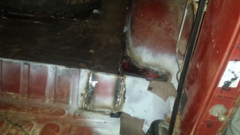 Photo of welded floor-pan repair inside a red truck cab