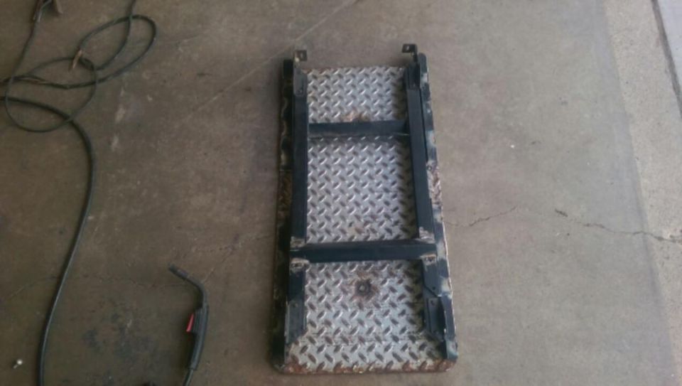 Photo of a diamond-plate step or skid plate on a garage floor