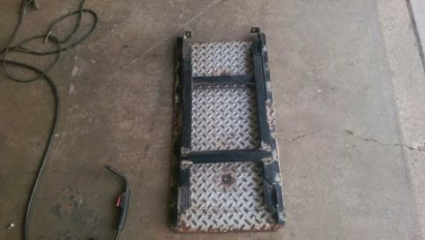 Photo of a diamond-plate step or skid plate on a garage floor