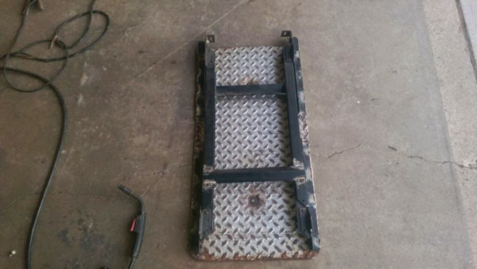 Photo of a diamond-plate step or skid plate on a garage floor