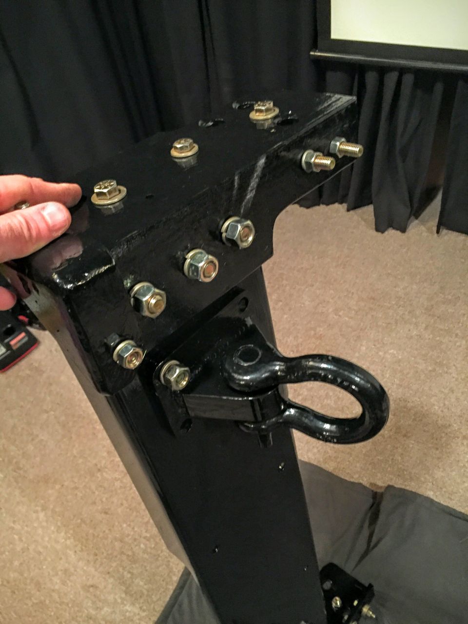 Photo of a black fabricated bracket with bolts and a D-ring shackle