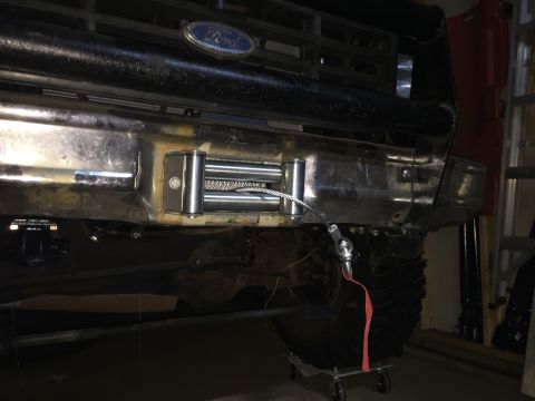 Photo of a winch mounted under a Ford truck front bumper in a garage