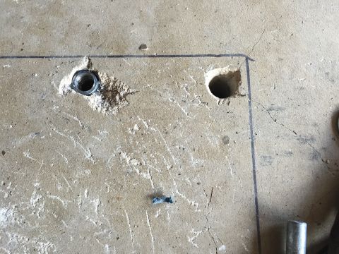 Drilled anchor holes in a concrete floor with marked layout lines