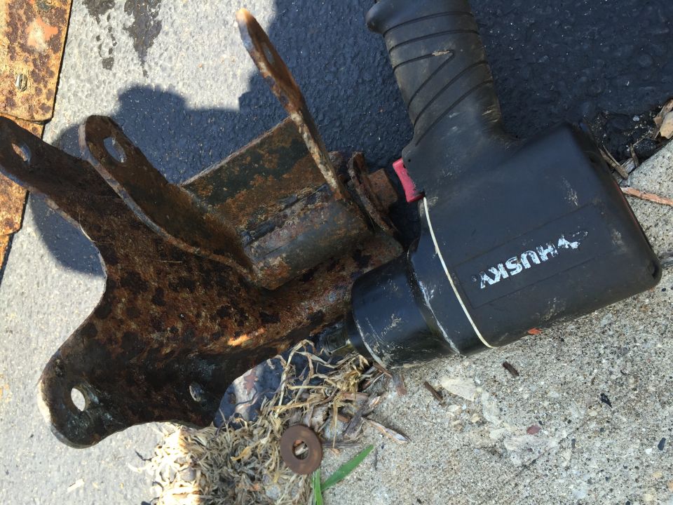 Rusty bracket and Husky impact wrench on pavement