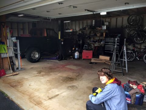 Garage interior with some equipment and a person sitting