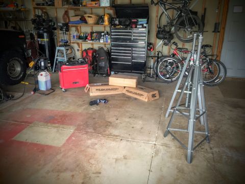 Interior of a cluttered garage with a tripod