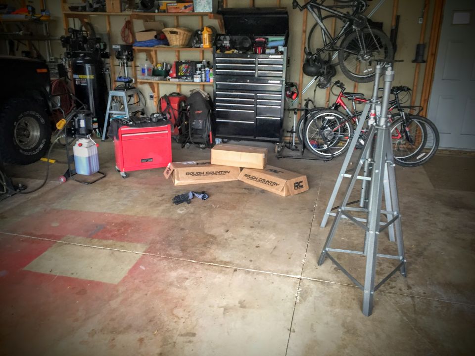 Interior of a cluttered garage with a tripod