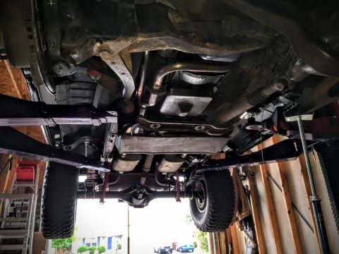 Underside view of a 4x4 vehicle on a lift, showing suspension and drivetrain components