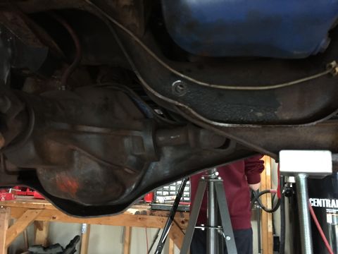 Underside view of a vehicle differential and axle on jack stands