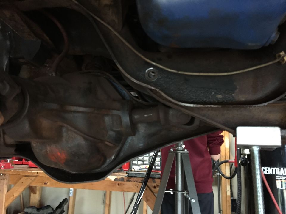Underside view of a vehicle differential and axle on jack stands