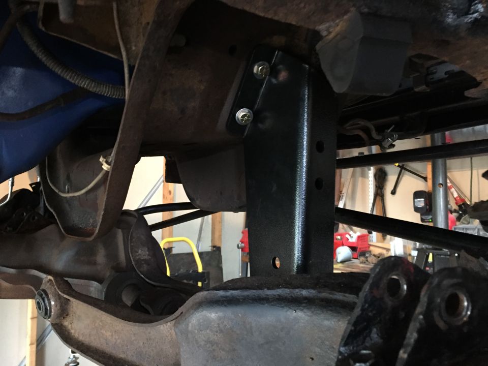 Newly installed black bracket bolted to a vehicle frame