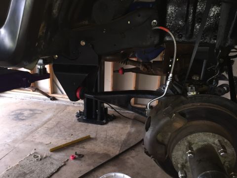 Underside view of a truck on a lift showing front suspension and brake hub