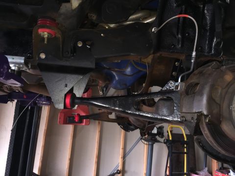 Underbody view of a truck front suspension with radius arm and bushings