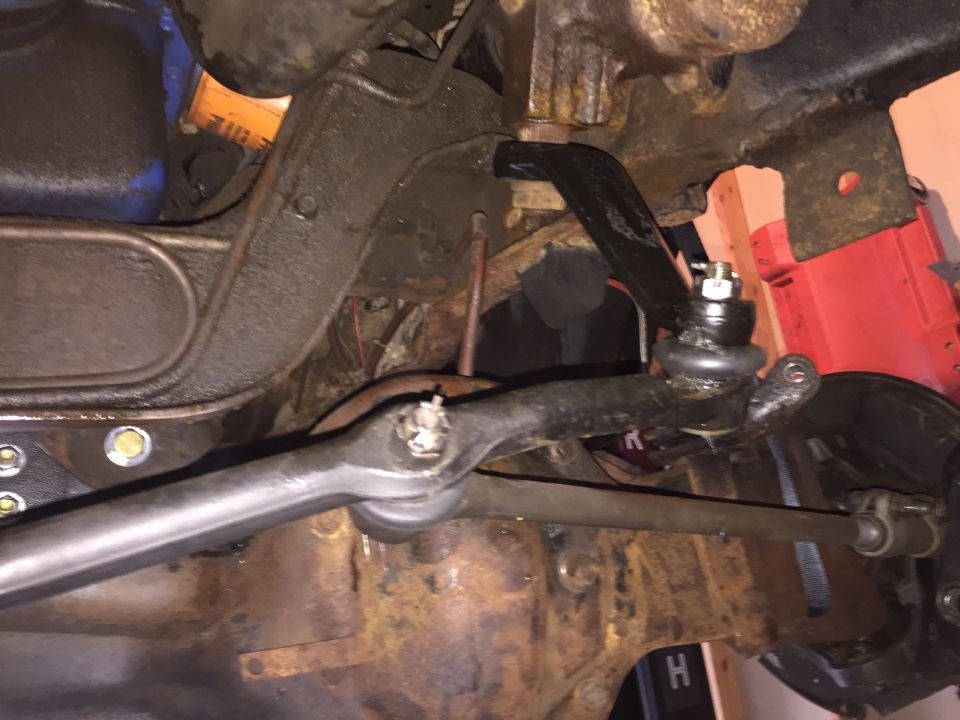 Close-up underside view of a truck steering linkage and tie rod end