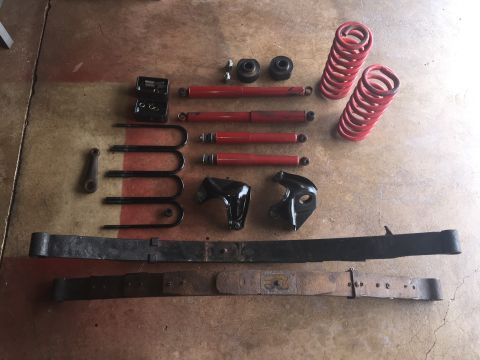 Suspension lift kit parts including coil springs, shocks, leaf springs, and brackets