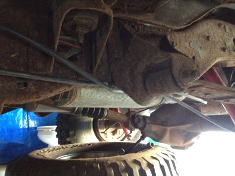 Underbody view of a 4x4 truck transfer case and rear driveshaft