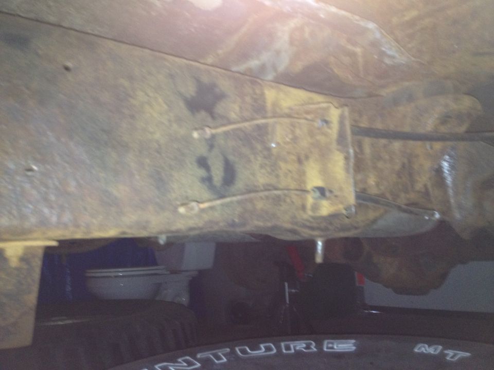 Photo of a vehicle frame crossmember and brake lines viewed from underneath