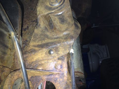 Photo of a rusty front suspension bracket and frame member